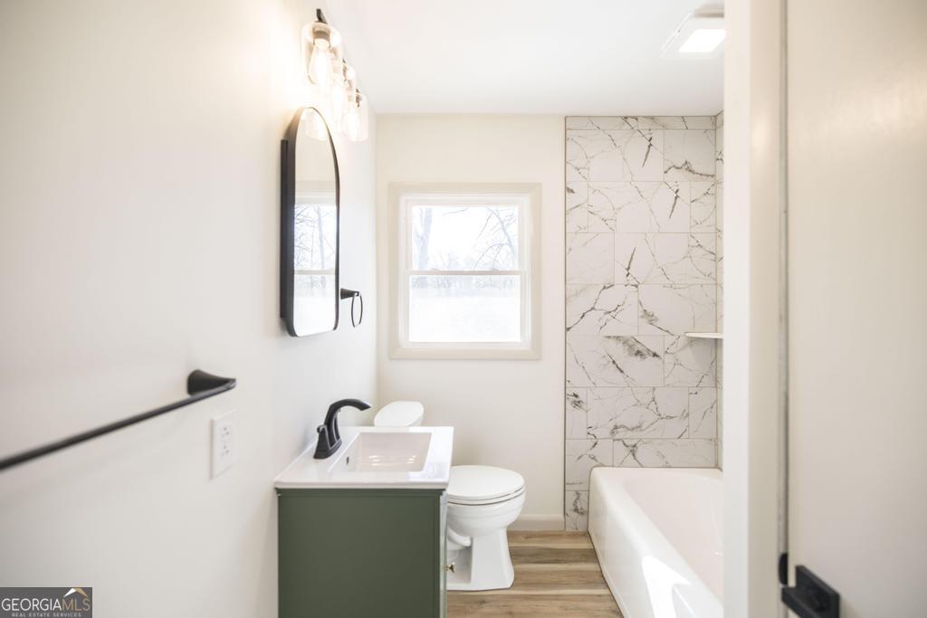 103 Spring Street Warner Robins, GA 31088 - Photo 17 of 30 a bathroom with a toilet sink vanity tub and shower