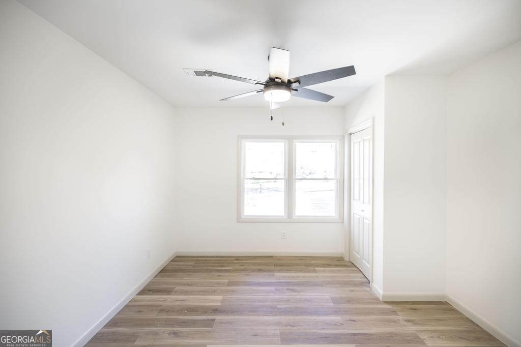 103 Spring Street Warner Robins, GA 31088 - Photo 24 of 30 an empty room with wooden floor and windows