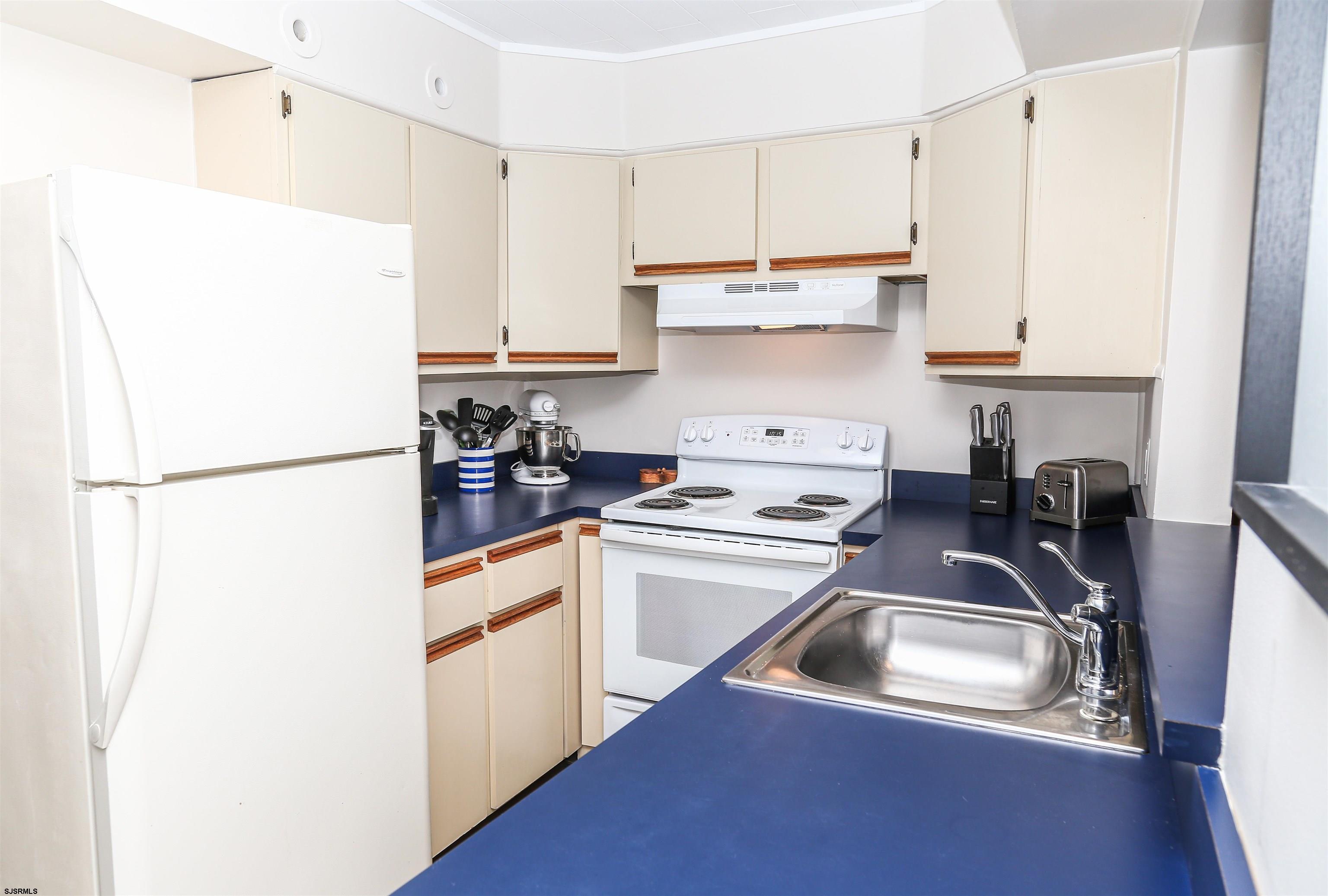 307 28th Street South Brigantine, NJ 08203 - Photo 10 of 38 a kitchen with a refrigerator sink and white cabinets
