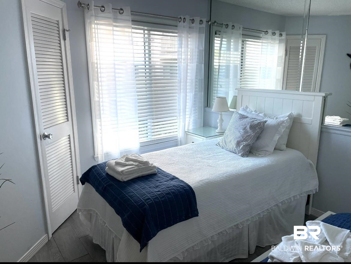 497 Plantation Road, Unit 1156 Gulf Shores, AL 36542 - Photo 19 of 28 Bedroom featuring baseboards and multiple windows