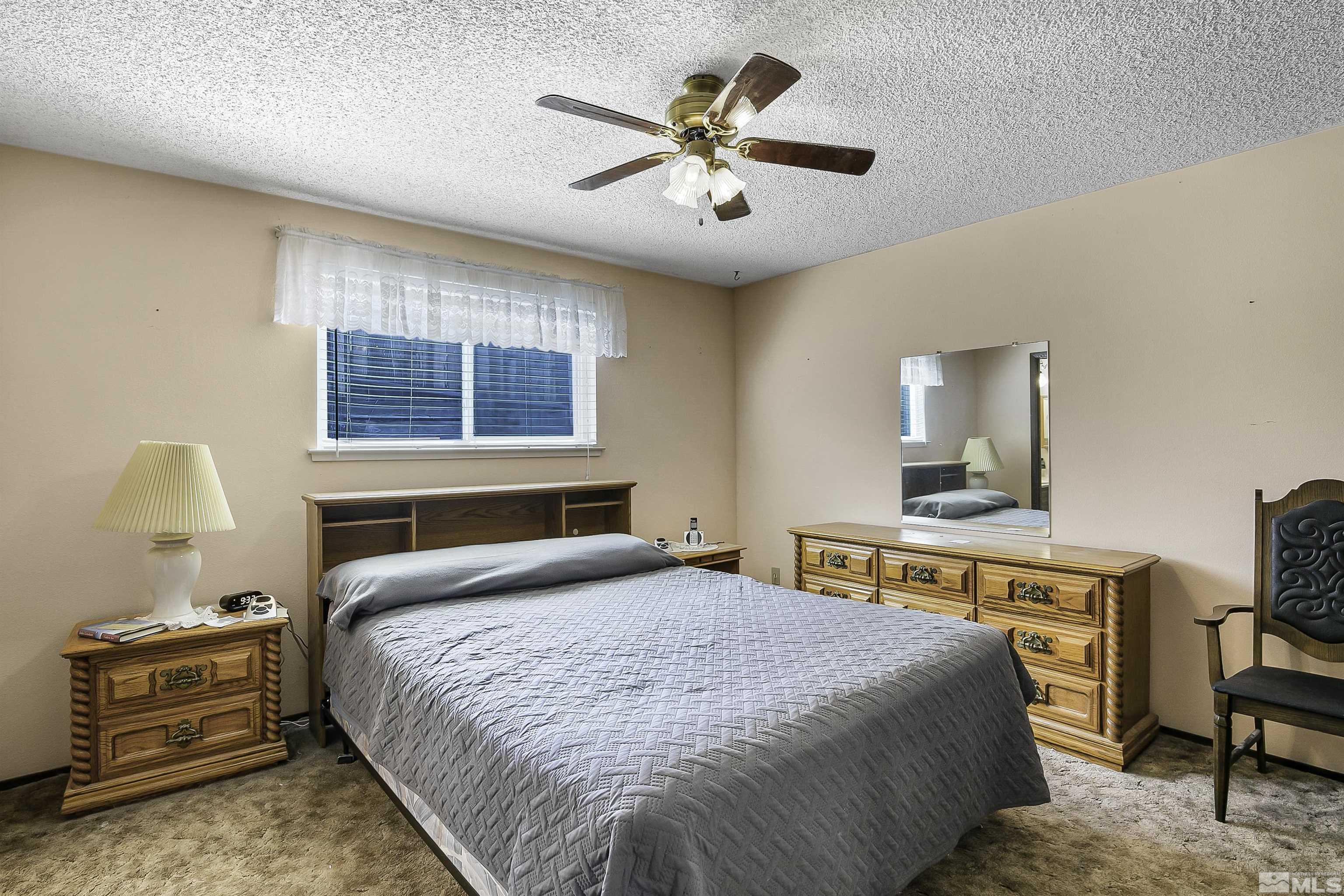 14075 Tourmaline Drive Reno, NV 89521 - Photo 18 of 37 a bedroom with a bed and a chandelier