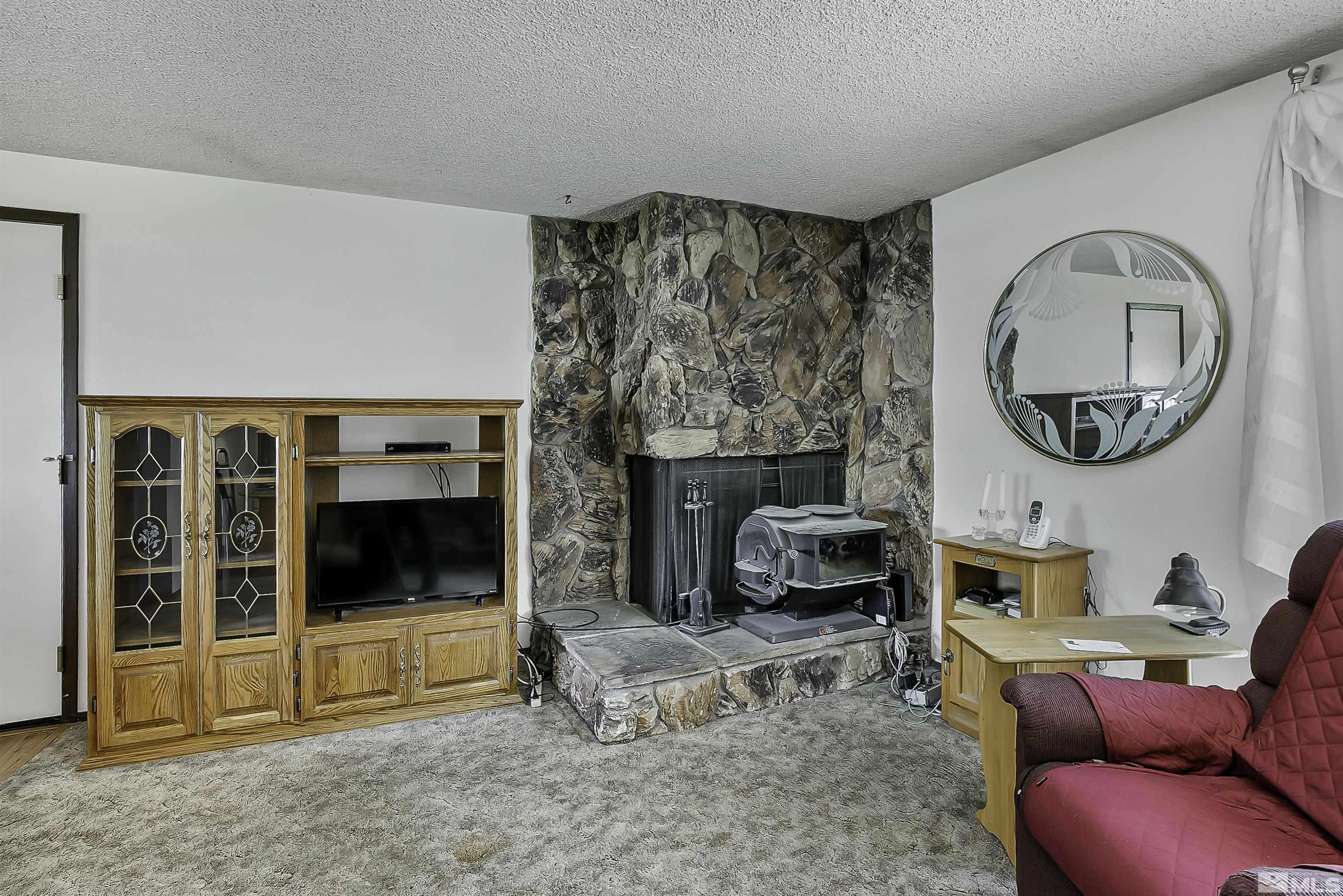 14075 Tourmaline Drive Reno, NV 89521 - Photo 3 of 37 a living room with furniture a flat screen tv and a fireplace