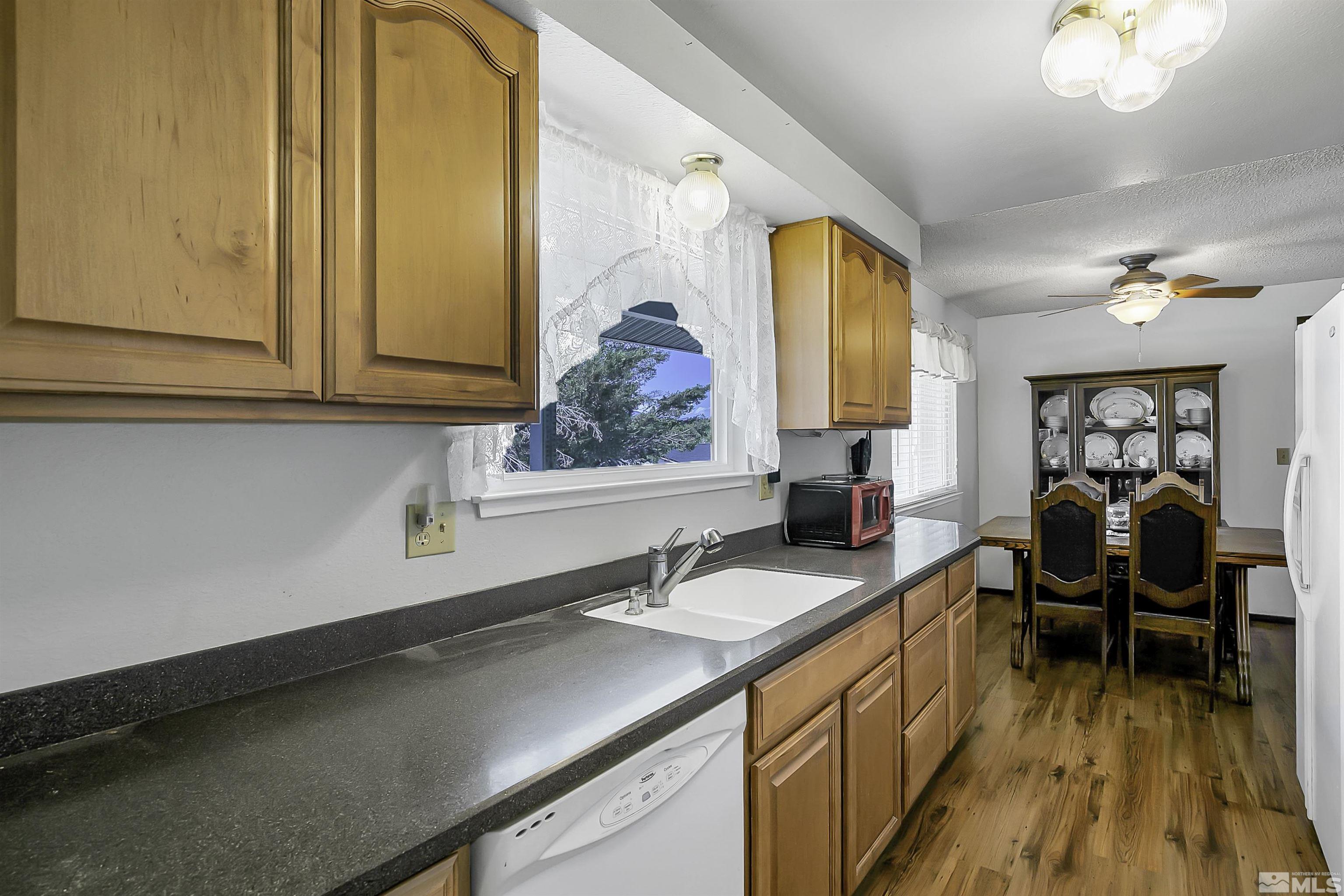 14075 Tourmaline Drive Reno, NV 89521 - Photo 8 of 37 a view of a kitchen with sink cabinets and wooden floor