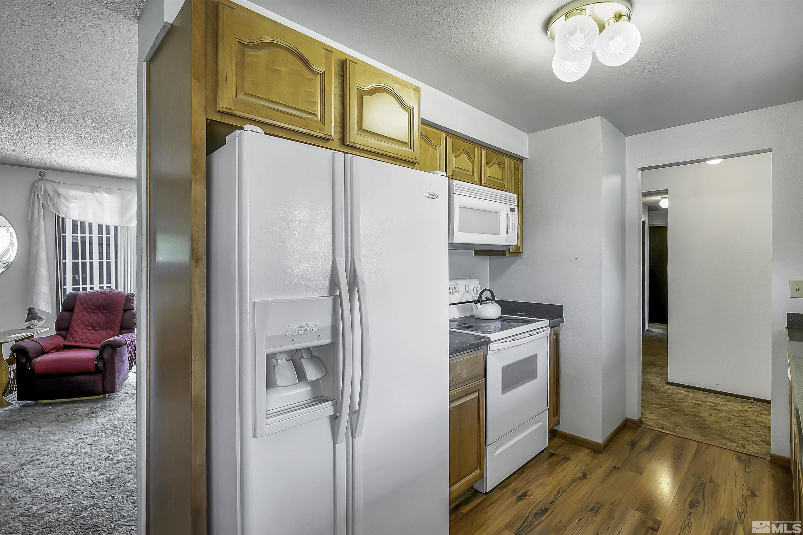 14075 Tourmaline Drive Reno, NV 89521 - Photo 9 of 37 a kitchen with stainless steel appliances granite countertop a refrigerator a stove and a sink