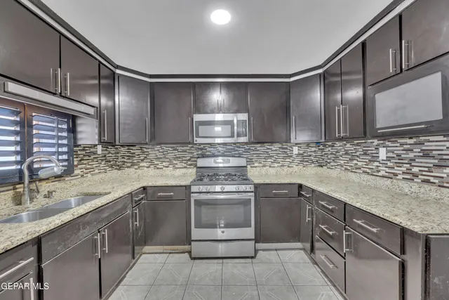 a kitchen with a sink stove and cabinets