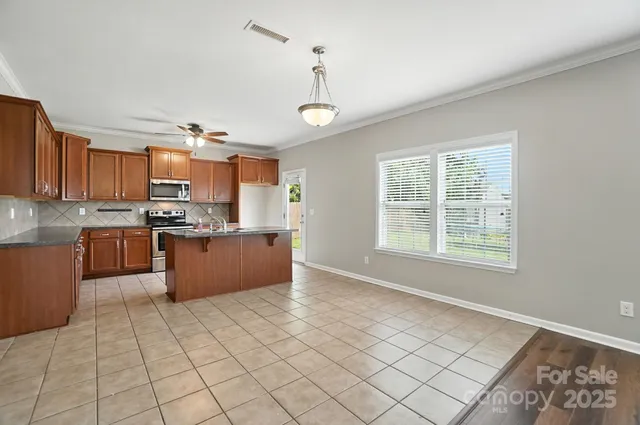 a kitchen with stainless steel appliances granite countertop a stove sink microwave and cabinets