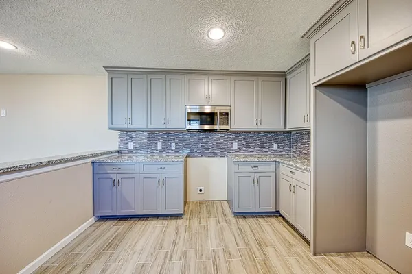 a kitchen with granite countertop cabinets stainless steel appliances a sink and a counter top space