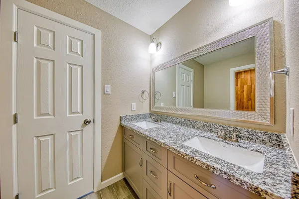 a bathroom with a granite countertop tub and a sink