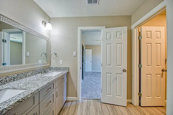 a spacious bathroom with a granite countertop sink and a mirror