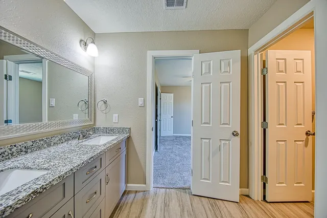 a spacious bathroom with a granite countertop sink and a mirror