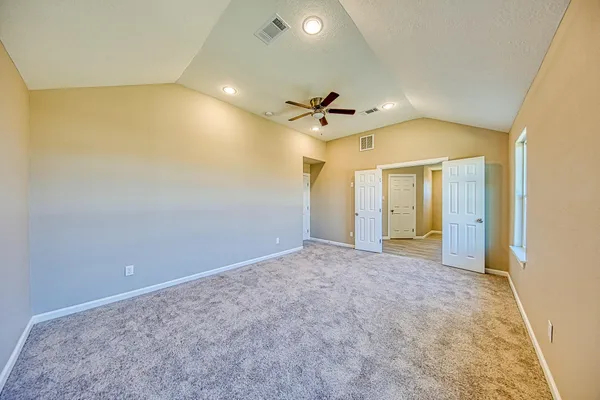 an empty room with a ceiling fan and a shower