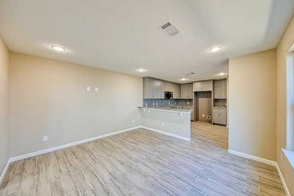 a view of kitchen electric appliances wooden floor and cabinets