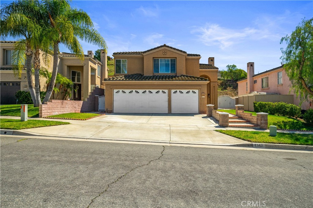 a view of a house with a yard and palm trees