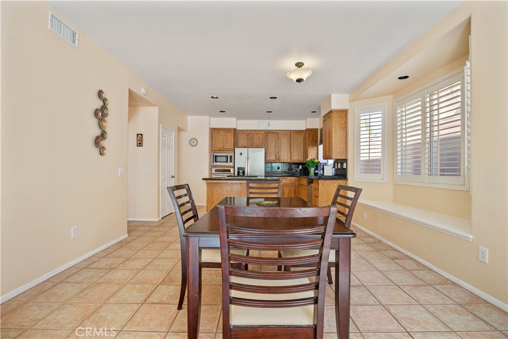 1147 Rosemary Circle Corona, CA 92879 - Photo 11 of 32 a dining hall with stainless steel appliances a dining table and chairs
