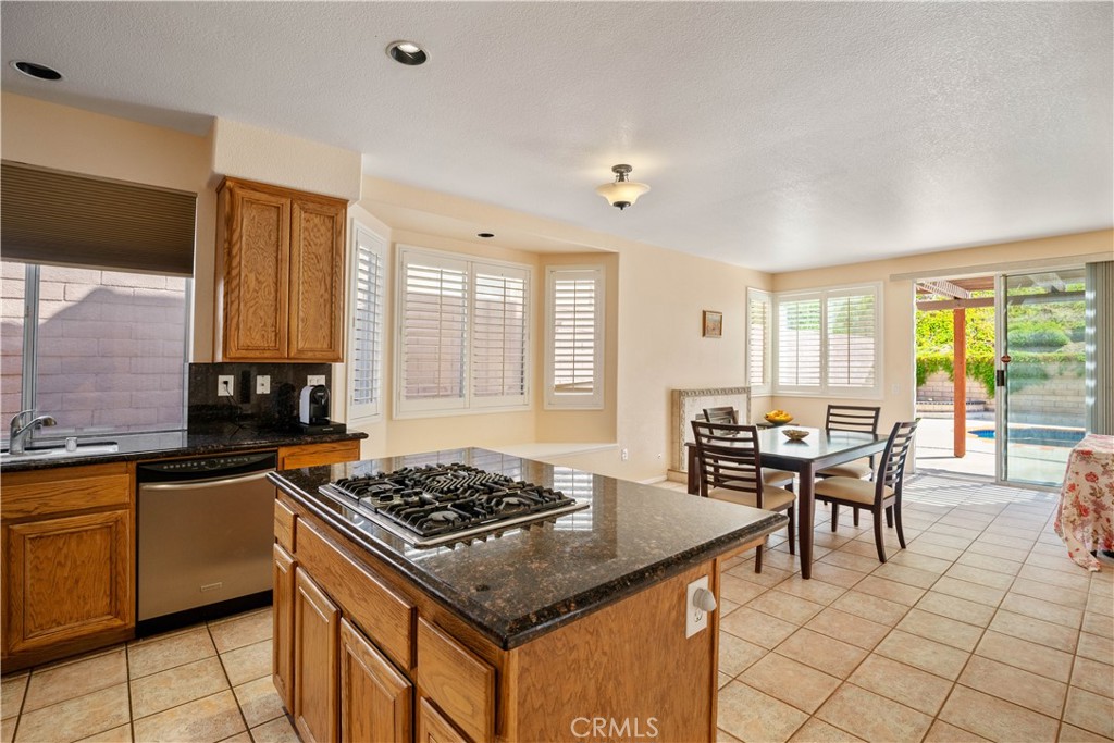 1147 Rosemary Circle Corona, CA 92879 - Photo 7 of 32 a kitchen with a stove a sink a dining table and chairs
