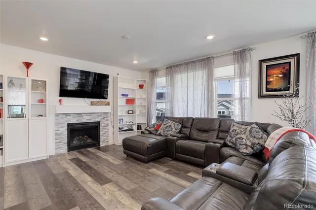 a living room with furniture a fireplace and a flat screen tv