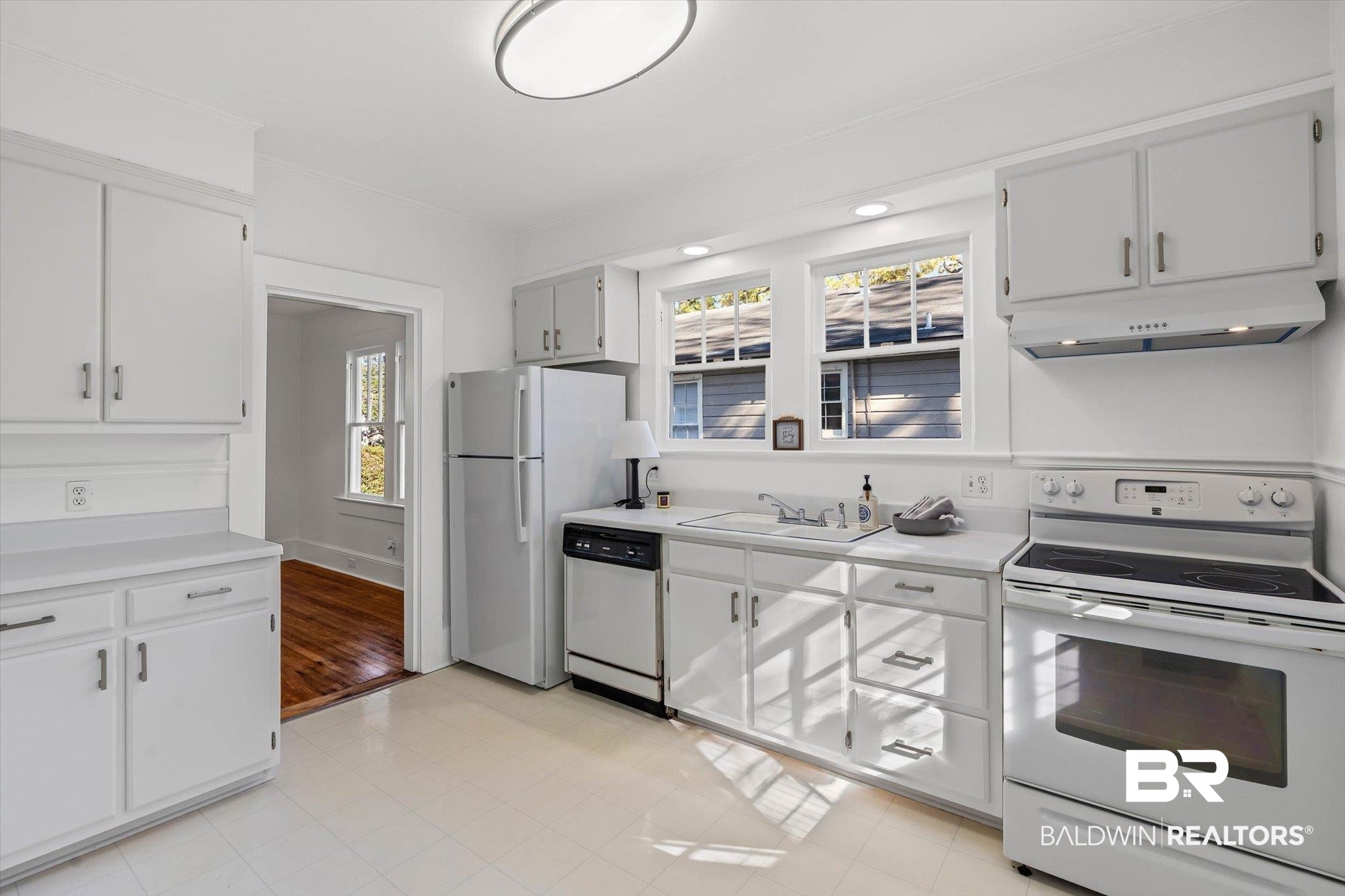 2153 Old Government Street Mobile, AL 36606 - Photo 6 of 23 Kitchen with white appliances, light countertops, under cabinet range hood, white cabinets, and recessed lighting