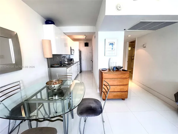 a view of a hallway with a white cabinet and a refrigerator