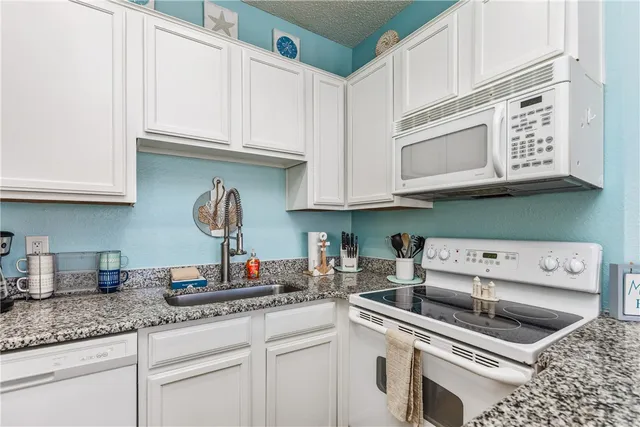 a kitchen with stainless steel appliances granite countertop a sink and a stove
