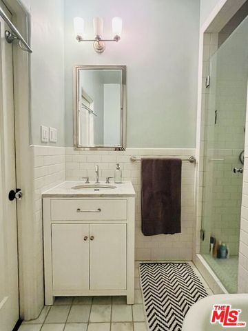 a bathroom with a sink a mirror and a shower