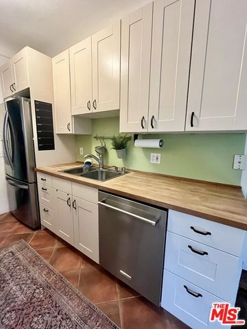 a kitchen with stainless steel appliances granite countertop a sink a stove and cabinets