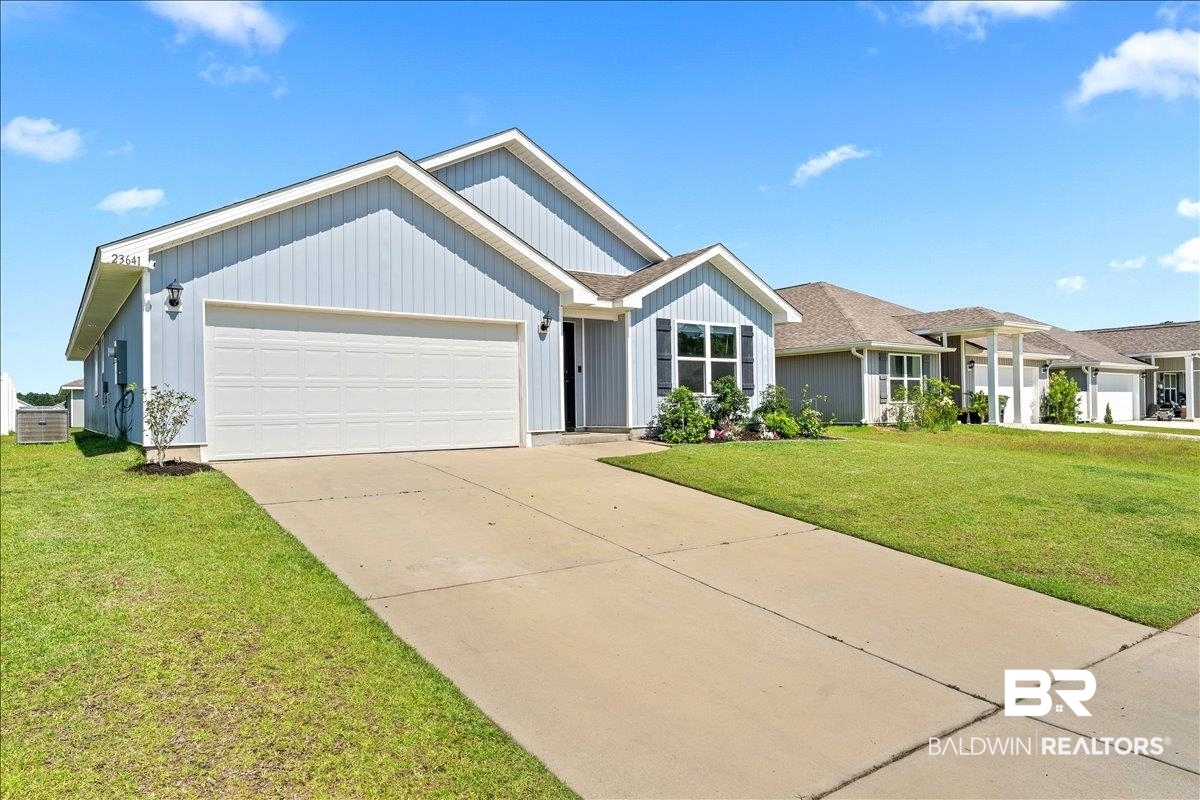 23641 Unbridled Loop Daphne, AL 36526 - Photo 3 of 40 Light blue siding exterior featuring a covered entry, attached garage, and a concrete driveway