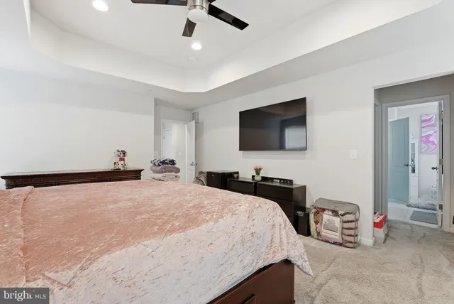 a bedroom with a bed and a flat tv screen on dresser
