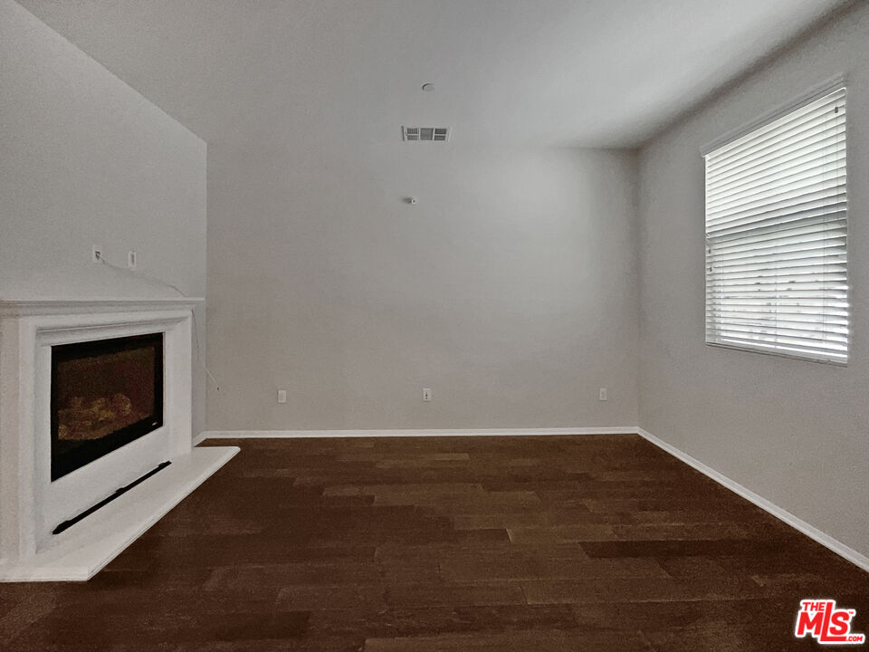 2234 Winifred Street, Unit 3 Simi Valley, CA 93063 - Photo 9 of 21 a view of an empty room with wooden floor and a fireplace