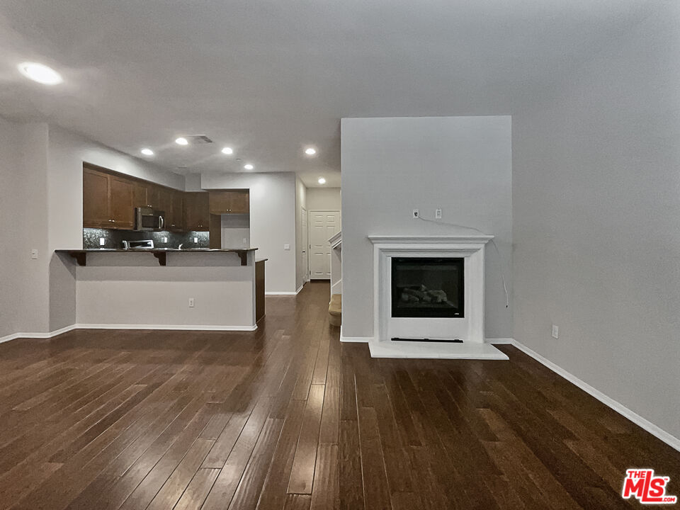 2234 Winifred Street, Unit 3 Simi Valley, CA 93063 - Photo 10 of 21 a view of a kitchen with wooden floor and a fireplace