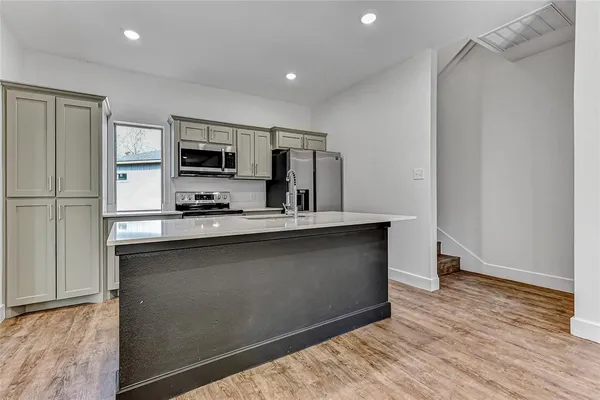 a kitchen with stainless steel appliances a refrigerator sink and microwave