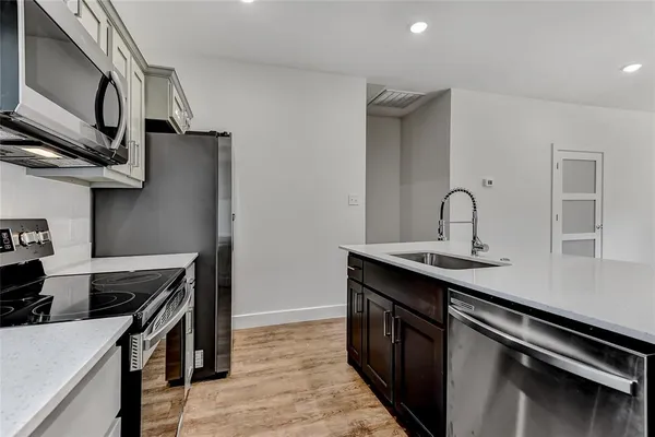 a kitchen with stainless steel appliances granite countertop a sink stove and cabinets