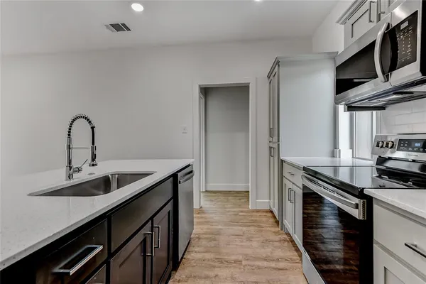 a kitchen with stainless steel appliances a sink stove and cabinets