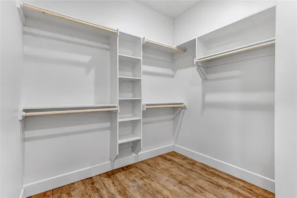 a view of walk in closet with empty racks