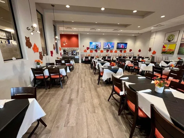 a front view of a building with a garden and trees