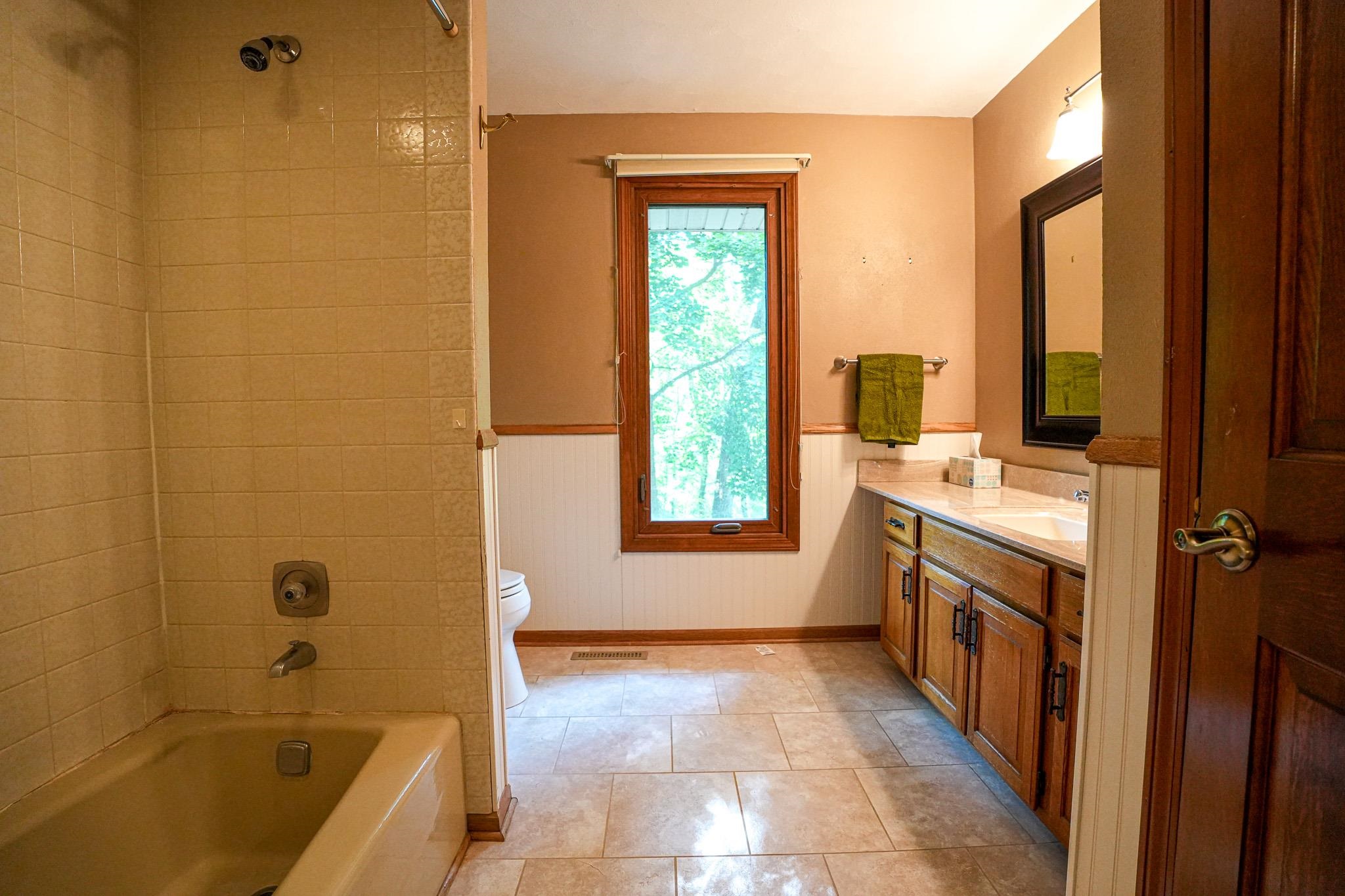 10340 William Trail Roscoe, IL 61073 - Photo 23 of 27 a bathroom with a tub sink and mirror