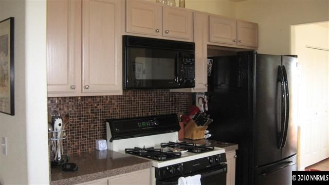 15075 Gooding Drive Reno, NV 89508 - Photo 6 of 9 a kitchen with granite countertop a stove and a microwave