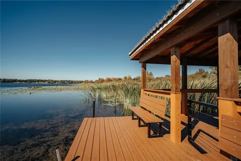 a view of a lake with wooden stairs and outdoor seating