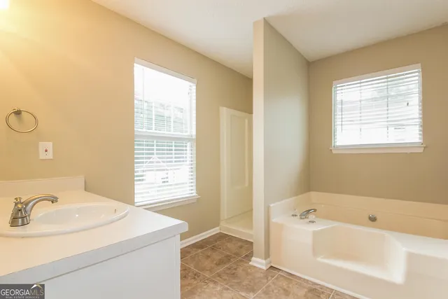 a bathroom with a tub sink and mirror