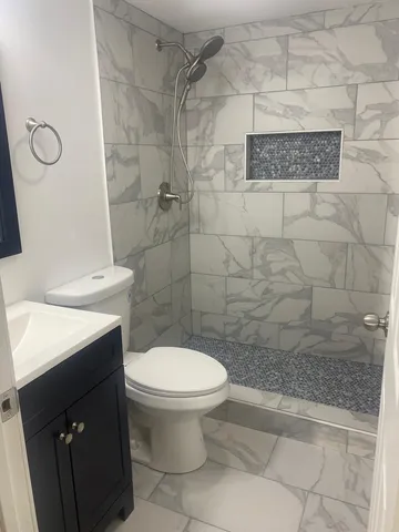 a bathroom with a toilet and a shower