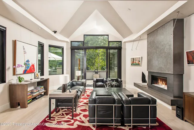a living room with furniture a fireplace and a floor to ceiling window