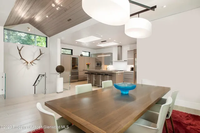 a kitchen with a table chairs and a chandelier