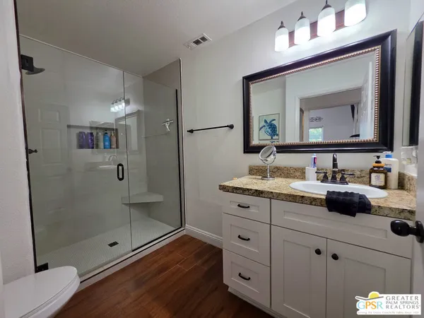 a bathroom with double vanity and a mirror