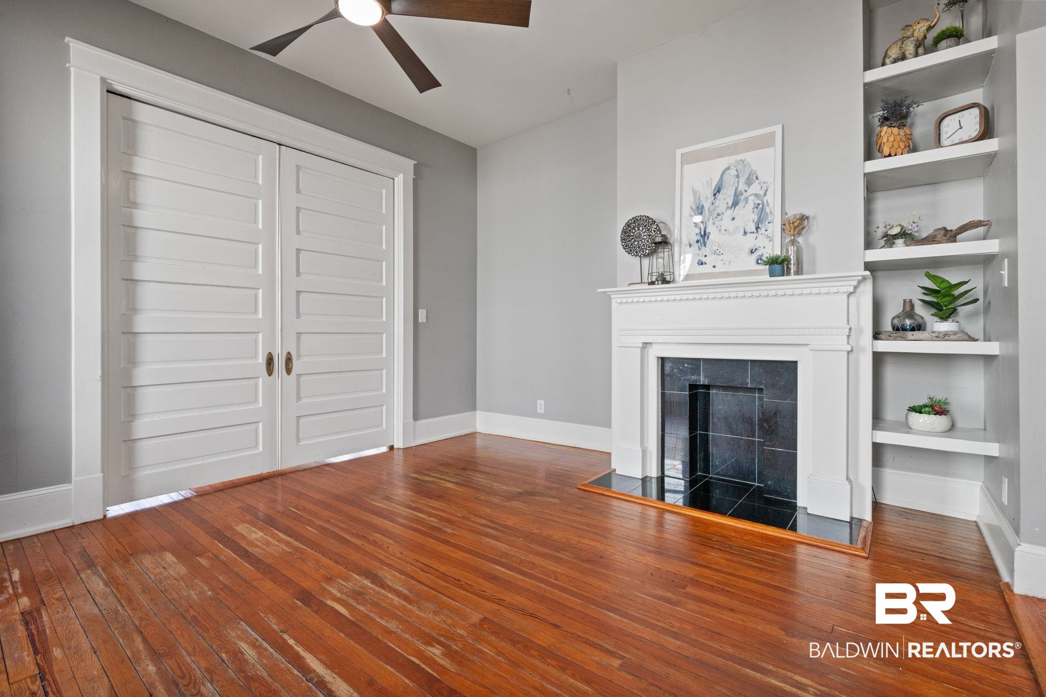 10 South Monterey Street Mobile, AL 36604 - Photo 12 of 45 Unfurnished living room with dark wood-style flooring, built in features, a fireplace, and ceiling fan