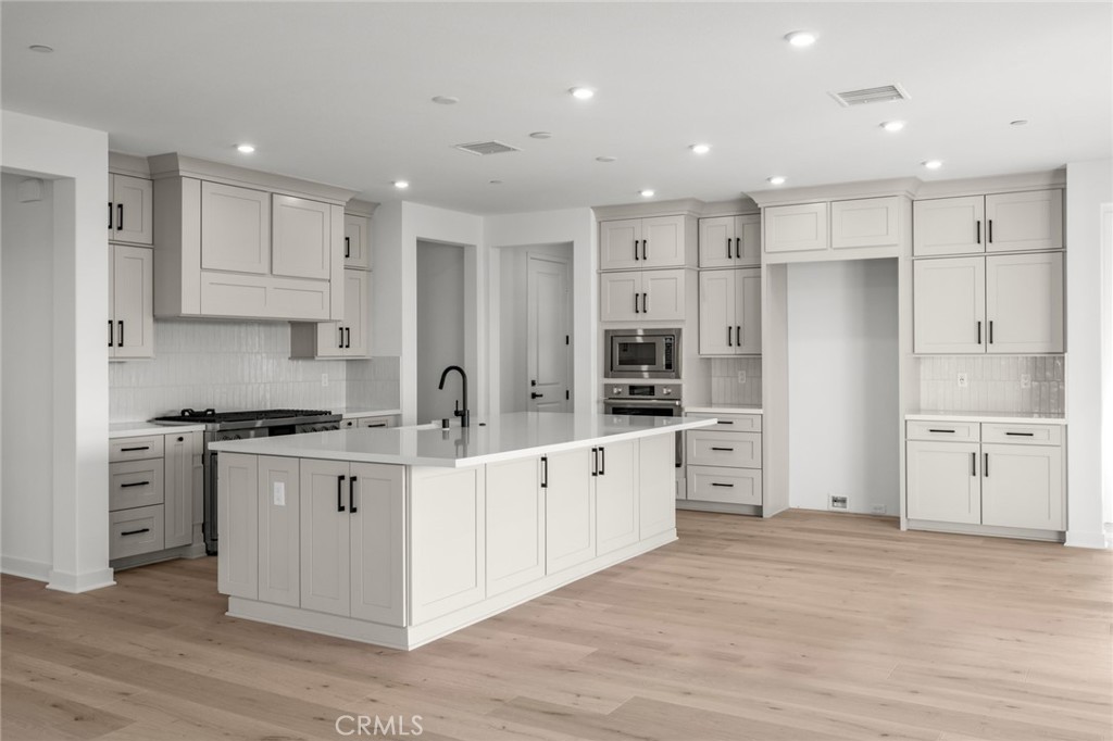 16642 Ginger Creek Drive Riverside, CA 92504 - Photo 14 of 22 a large white kitchen with stainless steel appliances granite countertop a stove and a refrigerator