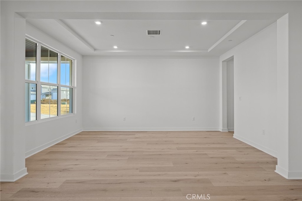 16642 Ginger Creek Drive Riverside, CA 92504 - Photo 18 of 22 a view of an empty room with wooden floor and a window