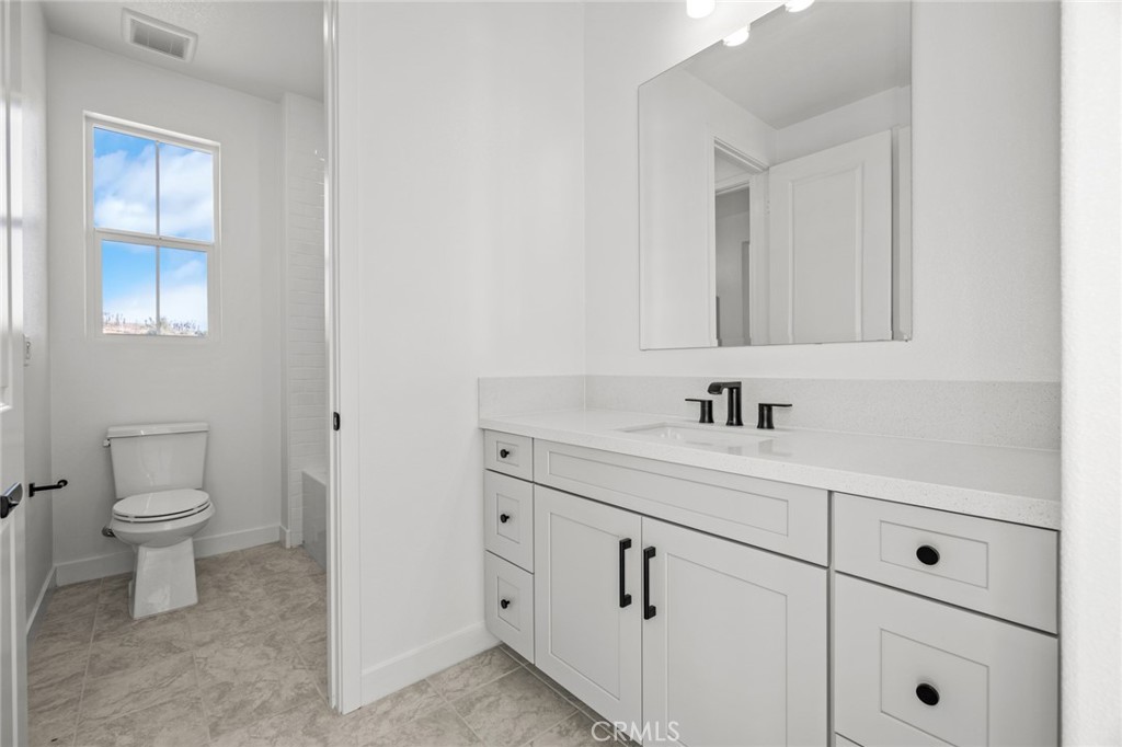 16642 Ginger Creek Drive Riverside, CA 92504 - Photo 8 of 22 a bathroom with a sink a toilet and a mirror