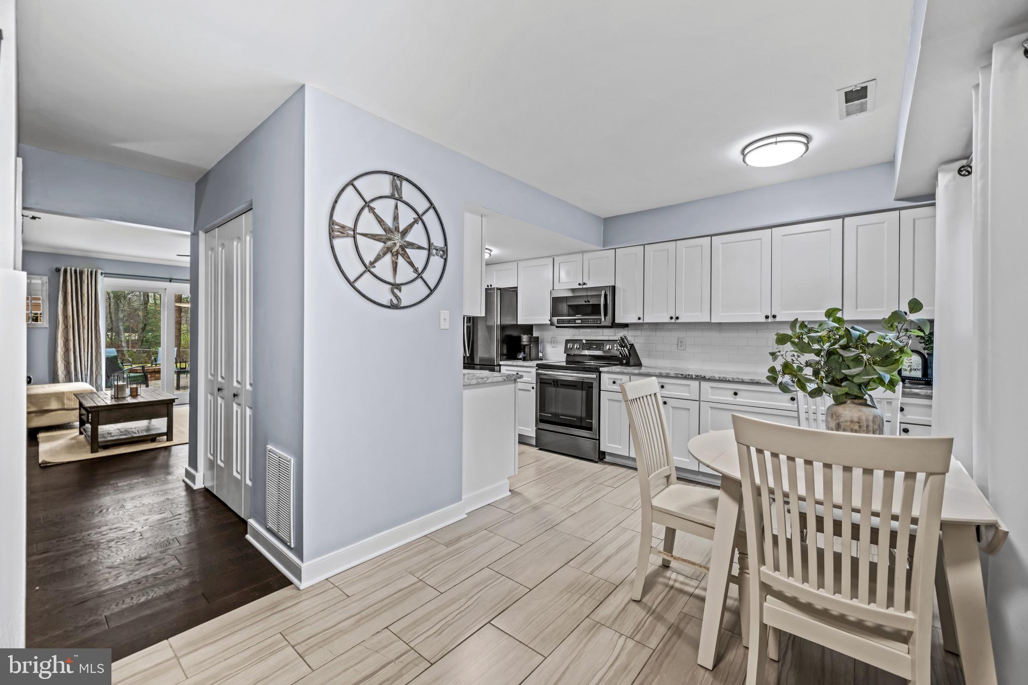 129 McKinsey Road Severna Park, MD 21146 - Photo 10 of 38 a kitchen with granite countertop a refrigerator a stove a sink and white cabinets