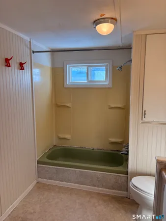 a bathroom with a toilet and a shower
