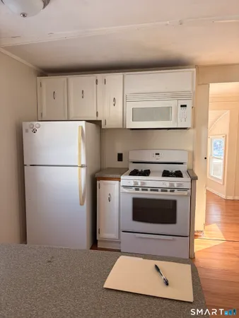 a kitchen with a stove cabinets and wooden floor