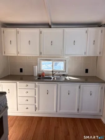 a kitchen with granite countertop white cabinets and white appliances